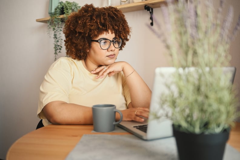 woman student in glasses studying online working on laptop computer at home office workspace. Remote work, distance education