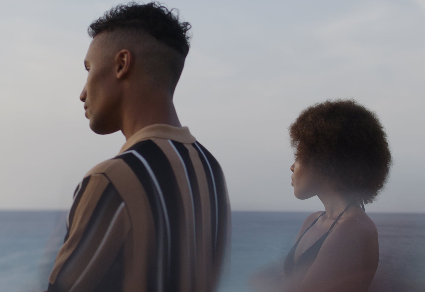 Couple standing next to each other looking in the same direction but avoiding gaze with each other