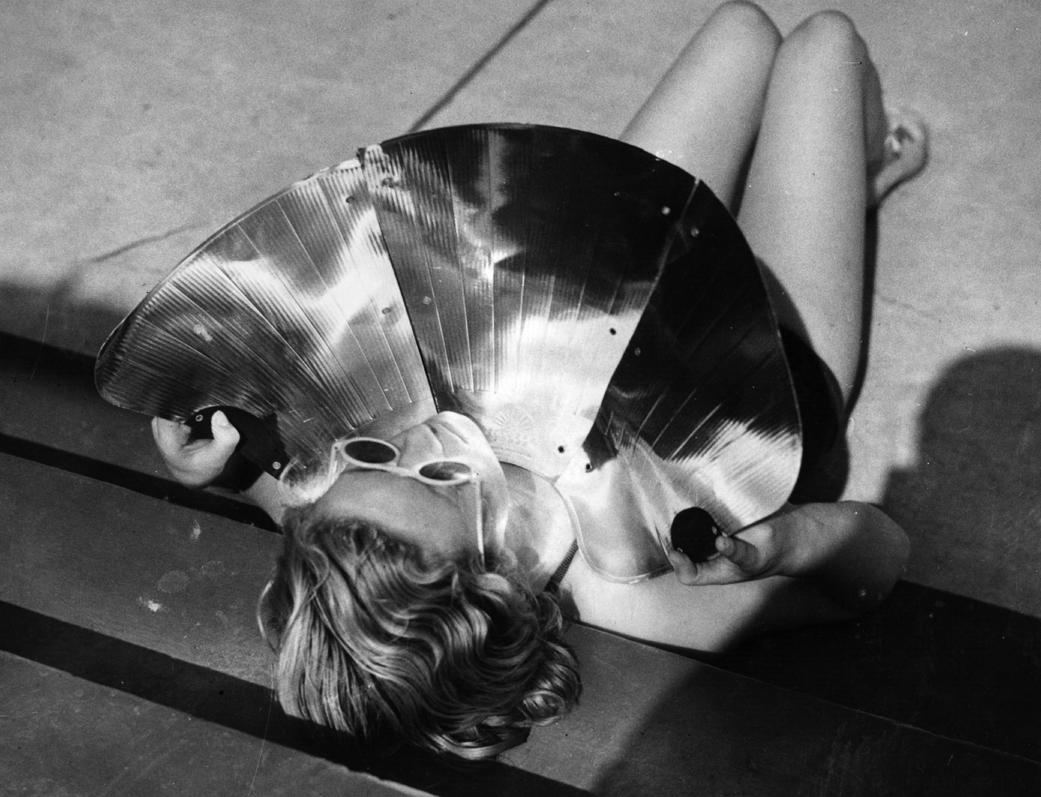 A sunbather in Hastings trying out a new invention for a quick tan using a polished shield which magnifies the heat of the sun.   (Photo by Gerry Cranham/Getty Images)