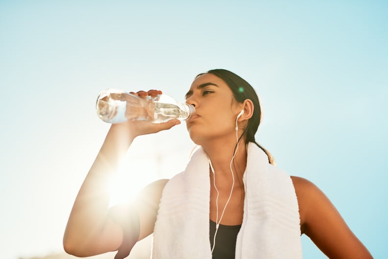 Shot of a sporty young woman taking a break while exercising outdoors