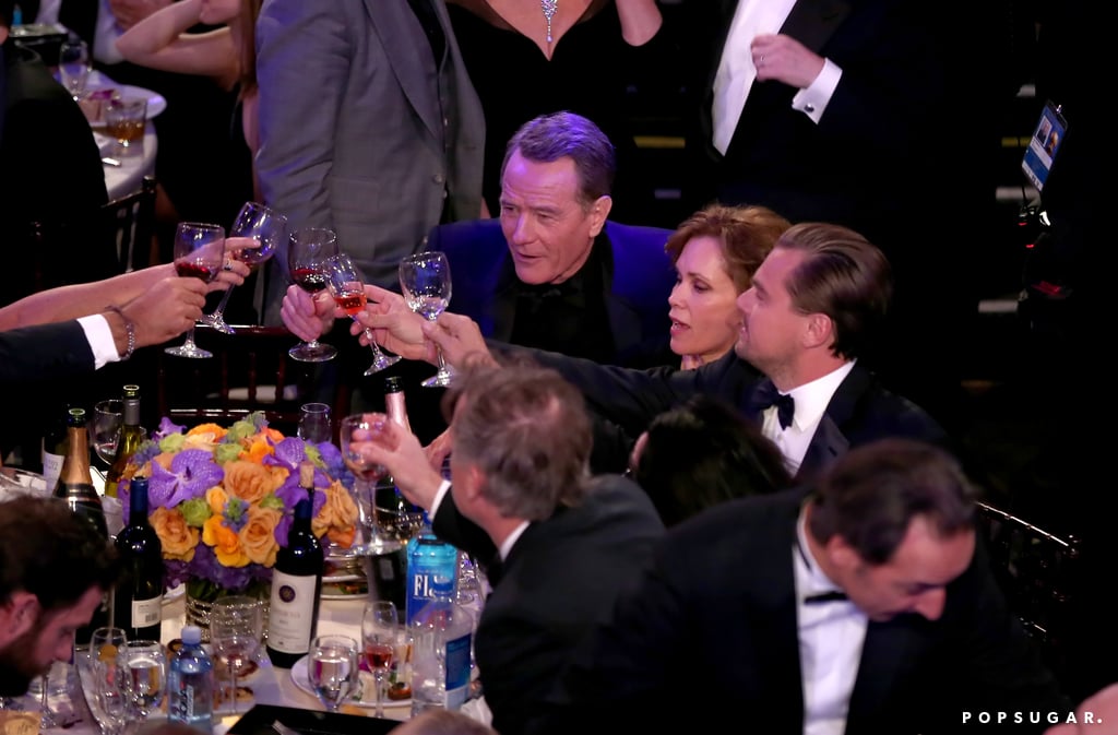 Leonardo DiCaprio toasted at his table with Bryan Cranston and Robin Dearden.