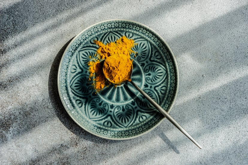 plate with a spoonful of turmeric to represent health benefits of turmeric