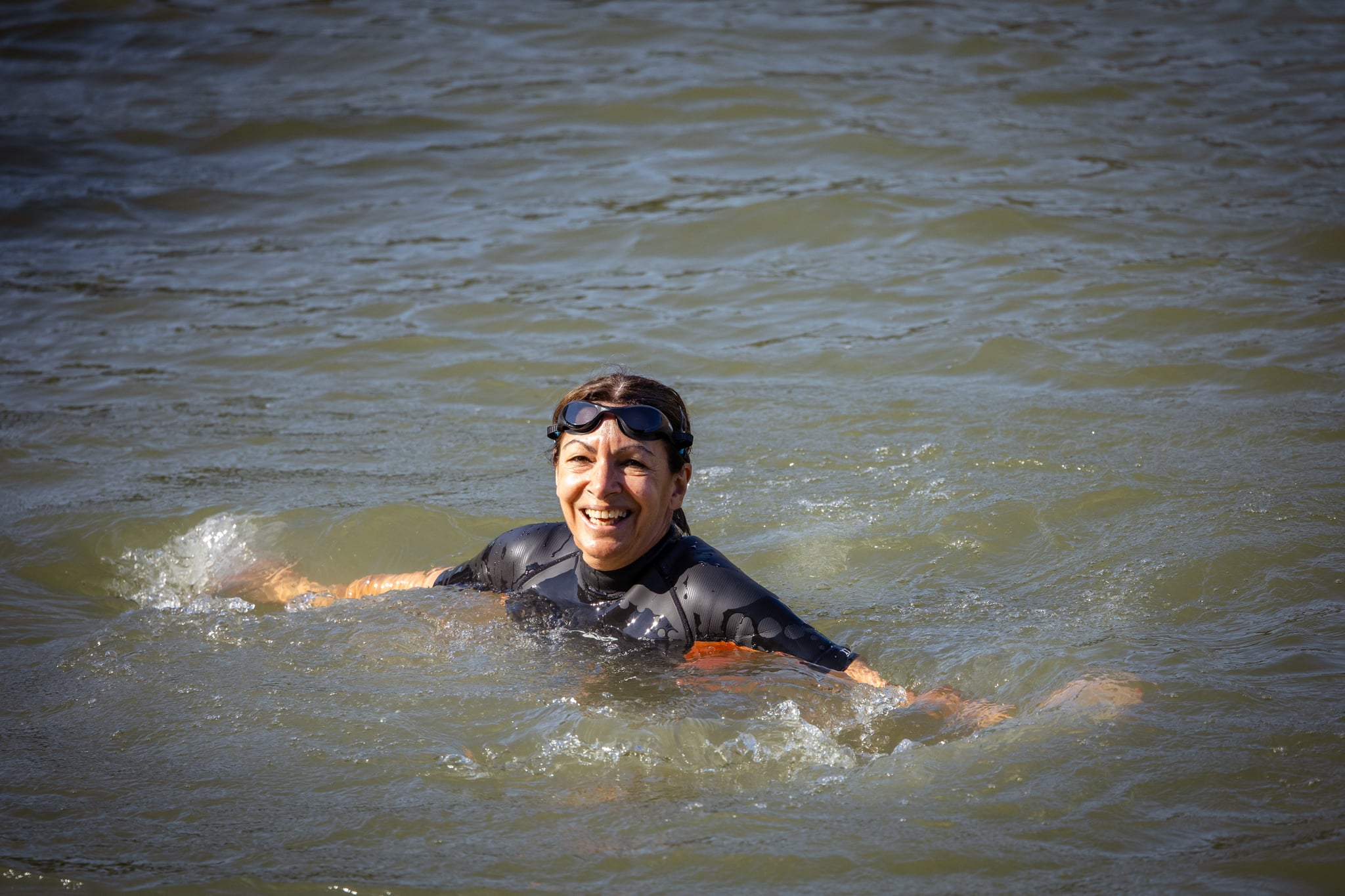 Paris Mayor Anne Hidalgo swims in a wetsuit and goggles in the Seine water at Bras Marie in Paris, France on July 17, 2024. Proof and swimming demonstration of the efforts made and spent by the City and the State to improve the quality of the water of the Seine, its bathability and the ecological state of the river which will host the open water swimming events during the Olympic and Paralympic Games JOP PARIS 2024. (Photo by Amaury Cornu / Hans Lucas / Hans Lucas via AFP) (Photo by AMAURY CORNU/Hans Lucas/AFP via Getty Images)