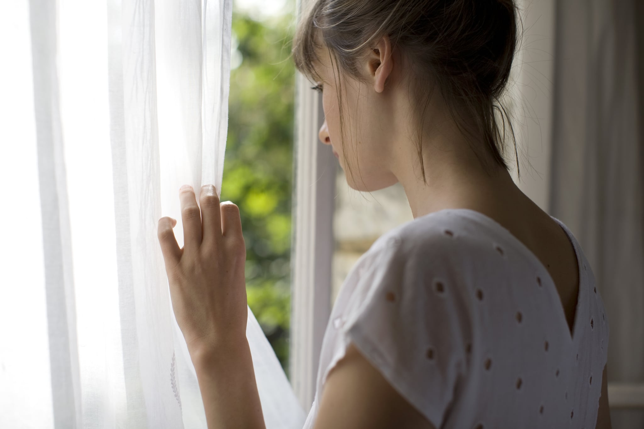 a woman is looking out of a window