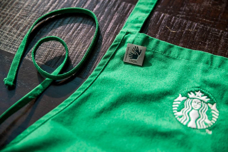 Hearing Partners Who Are Fluent in ASL Wear "I Sign" Pins on Traditional Green Aprons