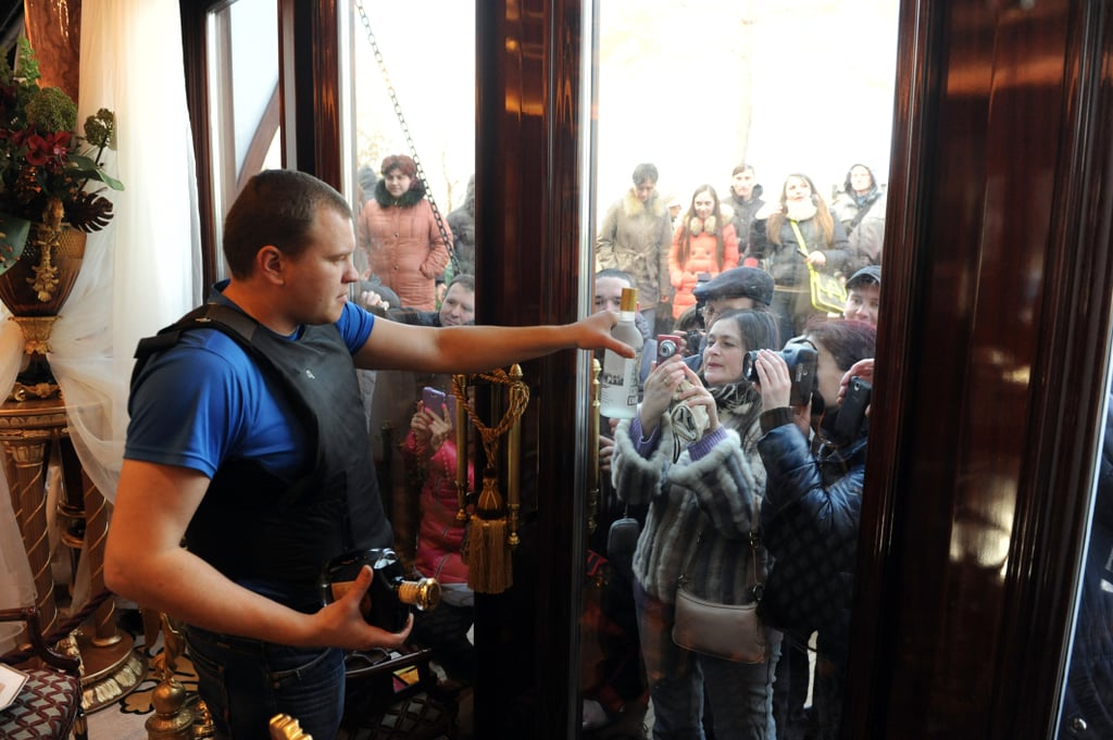 An antigovernment protester held up a bottle of liquor for people to photograph from the outside.