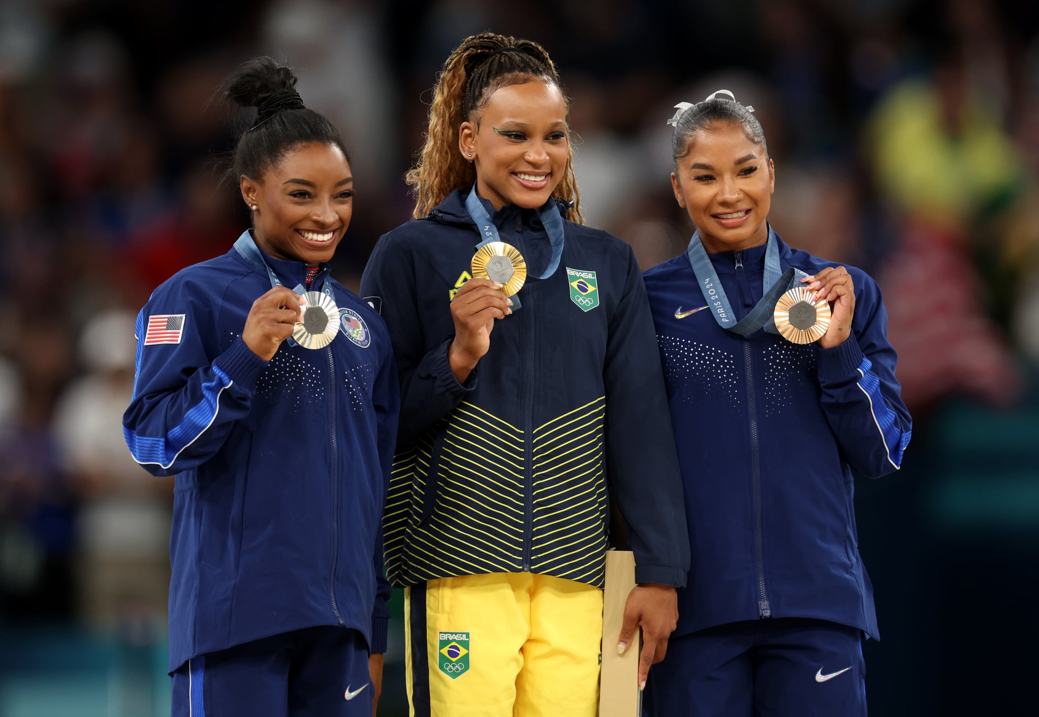 PARIS, FRANCE - AUGUST 05: Gold medalist Rebeca Andrade (C) of Team Brazil, silver medalist Simone Biles (L) of Team United States and bronze medalist Jordan Chiles (R) of Team United States pose on the podium at the Artistic Gymnastics Women's Floor Exercise Medal Ceremony on day ten of the Olympic Games Paris 2024 at Bercy Arena on August 05, 2024 in Paris, France. (Photo by Jamie Squire/Getty Images)