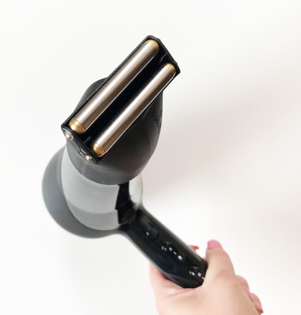 Here's what it looks like once I push it on the end of my blow dryer. It just adds about two inches of length to the end, so you don't feel much of a weight difference when you pick it up. Once you turn on your blow dryer, don't touch those metal rollers! They're going to get insanely hot.