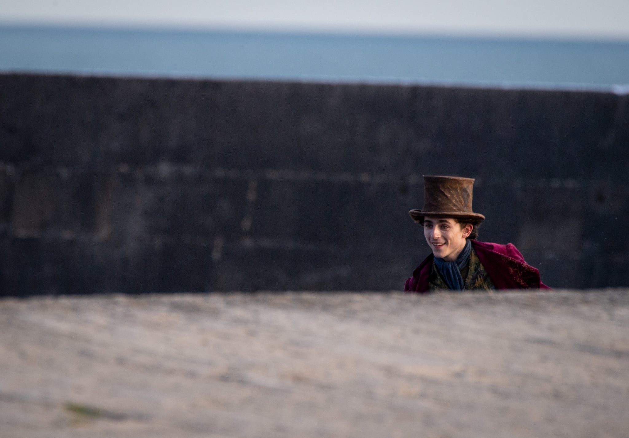 LYME REGIS, ENGLAND - OCTOBER 12: Timothée Chalamet is seen as Willy Wonka leaving the ship on the top of a van during filming for the Warner Bros and the Roald Dahl Story Company's upcoming movie 'Wonka' on October 12, 2021, in Lyme Regis, England. This film will focus on the young Willy Wonka on his earliest adventure and how he met the Oompa-Loompas. (Photo by Finnbarr Webster/Getty Images)