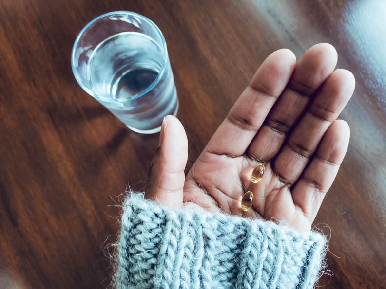 Close-up of woman's hand holding Vitamin D supplements