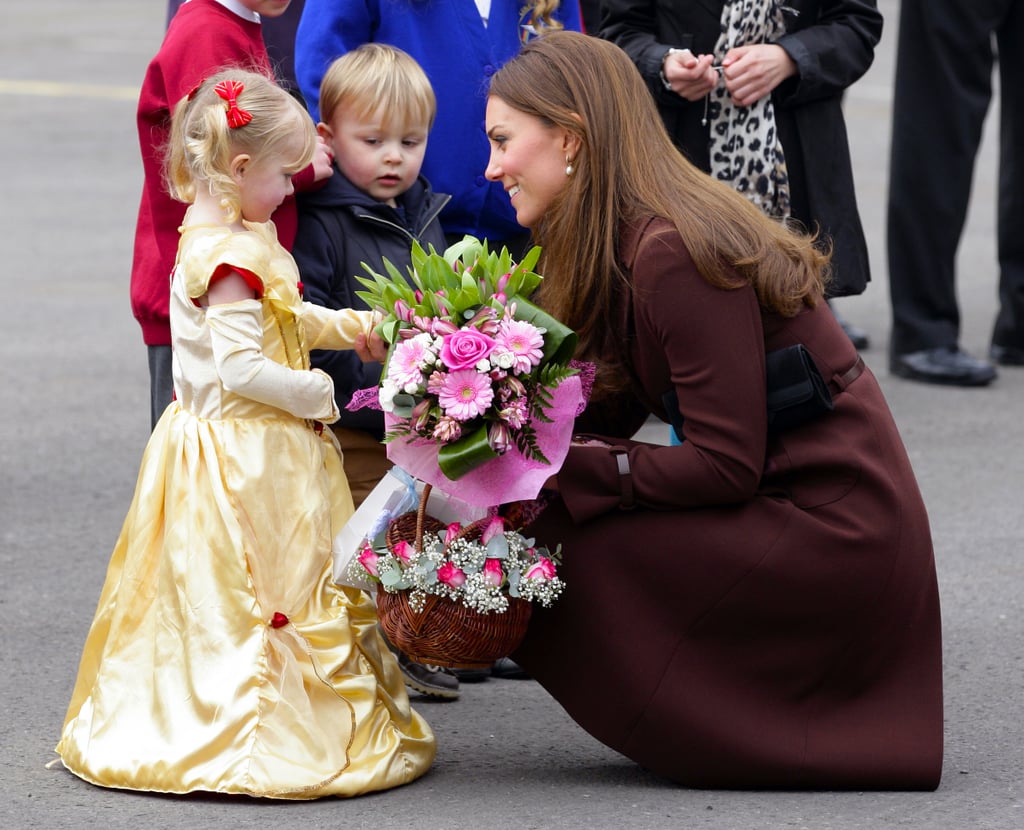 In this truly adorable moment, Kate knelt to speak to a little girl in a princess costume who greeted her with flowers in March 2013.