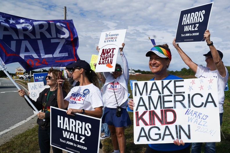 People hold signs in support of Democratic presidential nominee Vice President Kamala Harris.