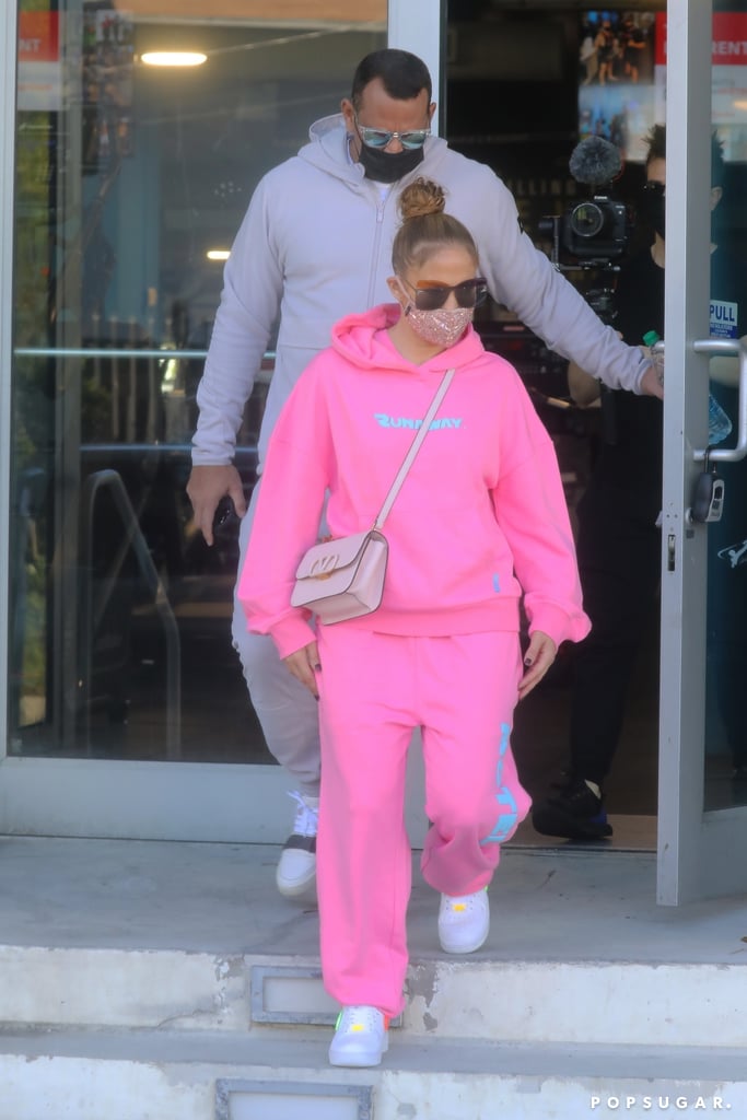 Wearing a neon-pink "Runaway" sweatsuit with a Valentino bag.