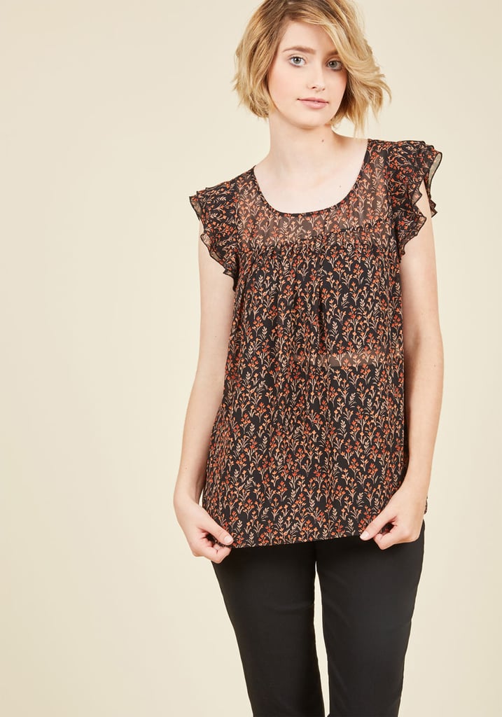 Ruffle Top ($45)
Opt for a patterned version of your favorite flirty top to pair with the overalls. The breezy texture of this one balances out nicely with the heavier texture of the overalls, while the delicate floral print in moody hues adds a nice Autumn touch.
