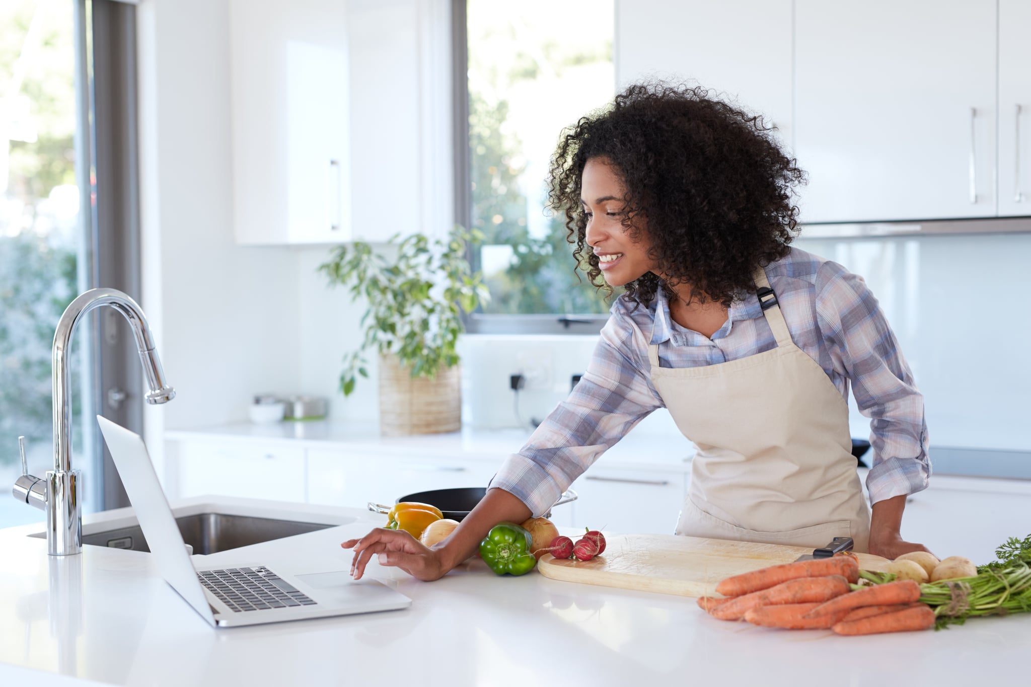 Shot of a young woman looking at an online recipe on her tablet while preparing a mealhttp://195.154.178.81/DATA/i_collage/pu/shoots/805714.jpg