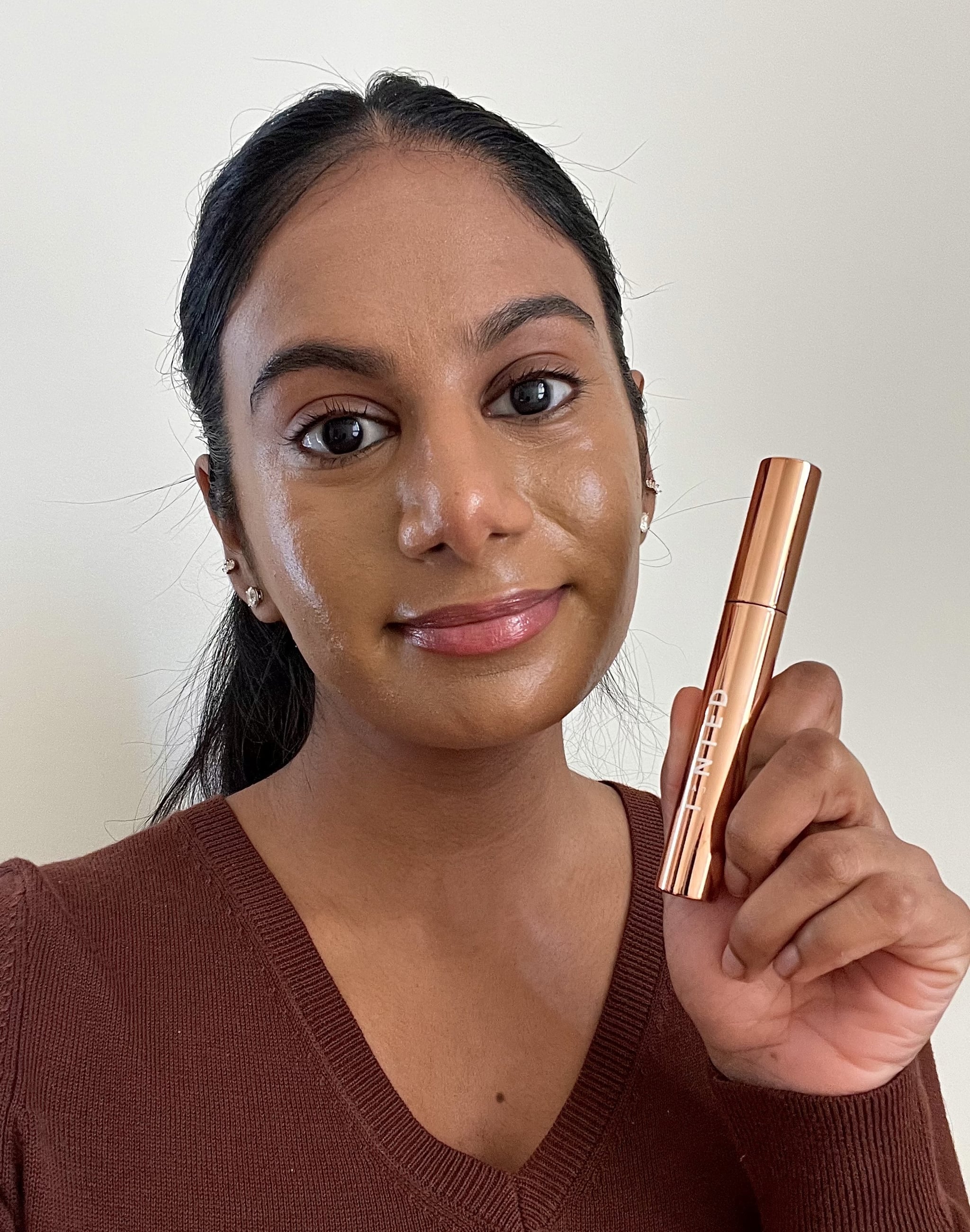 Imagen de una mujer sosteniendo el Live Tinted Huebrow con cejas definidas y definidas y pelos de bebé domesticados y volantes.