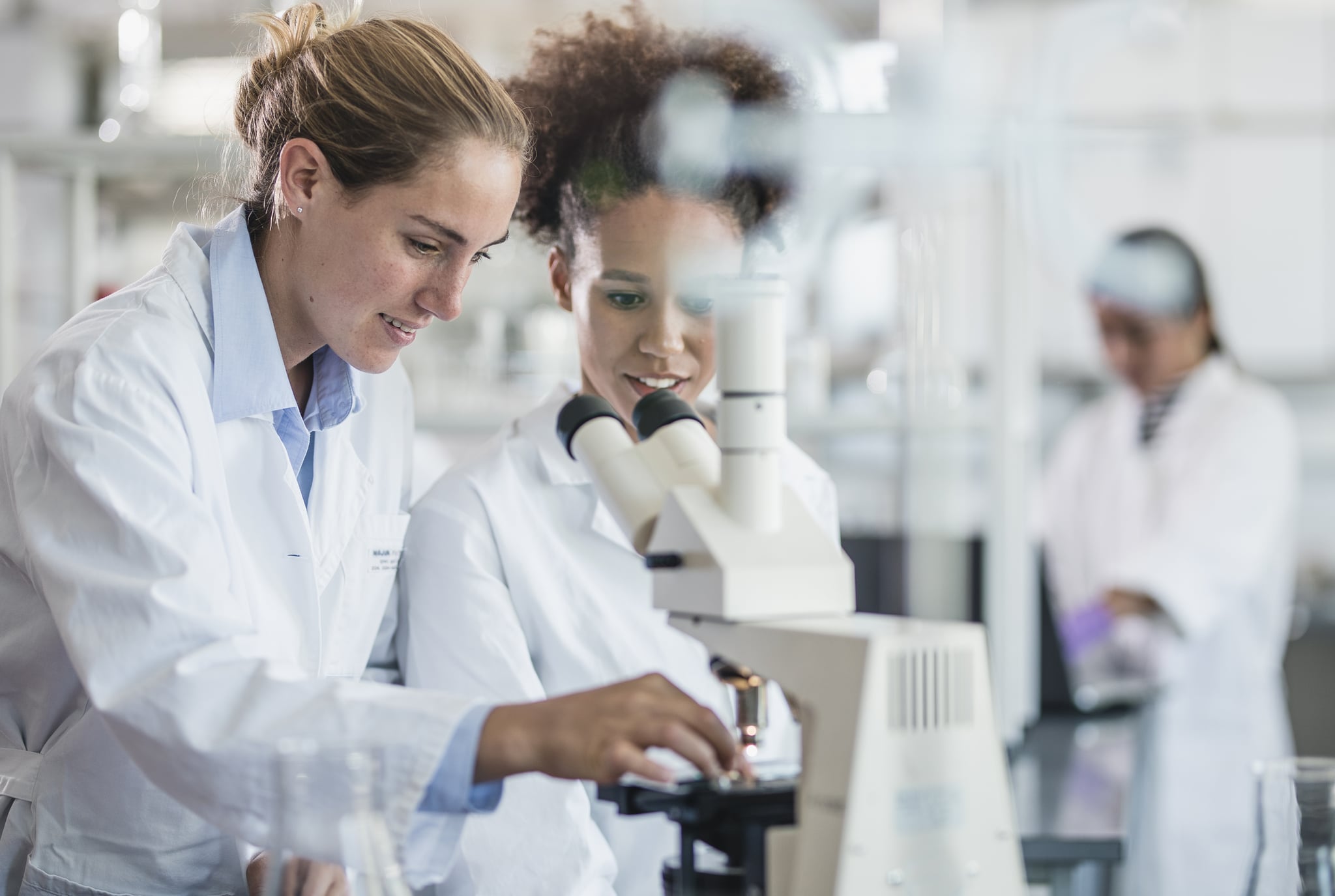 Female Scientists Beside a Microscope