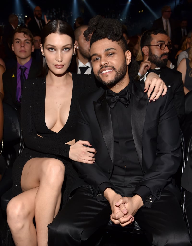 Bella Hadid and The Weekend arrived in style at the Grammys on Monday evening. The couple, who appears to still be going strong, coordinated their looks in all-black ensembles and stayed close while posing for photographers on the red carpet. Bella and The Weeknd were first linked back in April 2015, and the award ceremony marks the pair's first red carpet appearance together. In an interview with Rolling Stone, The Weeknd revealed that he "asked her to be on the artwork for Beauty Behind the Madness," and after she declined he decided to meet with her face-to-face, and the relationship "just kind of fell into my lap." 
Inside, the singer delivered a sultry performance of his hit singles "Can't Feel My Face" and "In the Night," and took home two Grammy awards for best R&B performance and best urban contemporary album. He was also seated next to Adele, whom he shared a couple of cute moments with during the show. Keep reading to see more of Bella and The Weeknd, and then check out even more celebrity couples at the Grammys.