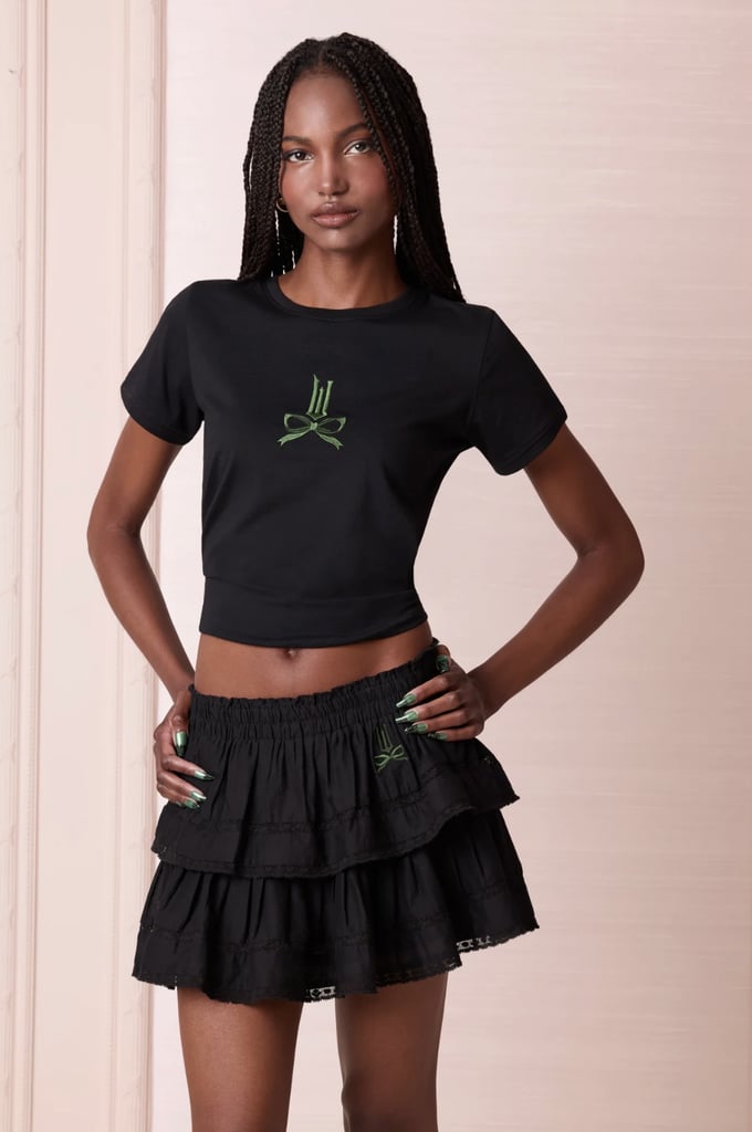 Wicked x LoveShackFancy Lia Tee ($95)
Tap into your inner Elphaba with a chic find from beloved brand LoveShackFancy that you'll wear long after the movie is out of theaters. This stylish tee features the signature "Wicked: For Good" logo with a whimsical bow attached — and pairs well with everything from denim to the matching skirt: Wicked x LoveShackFancy Ruffle Mini Skirt ($275).
