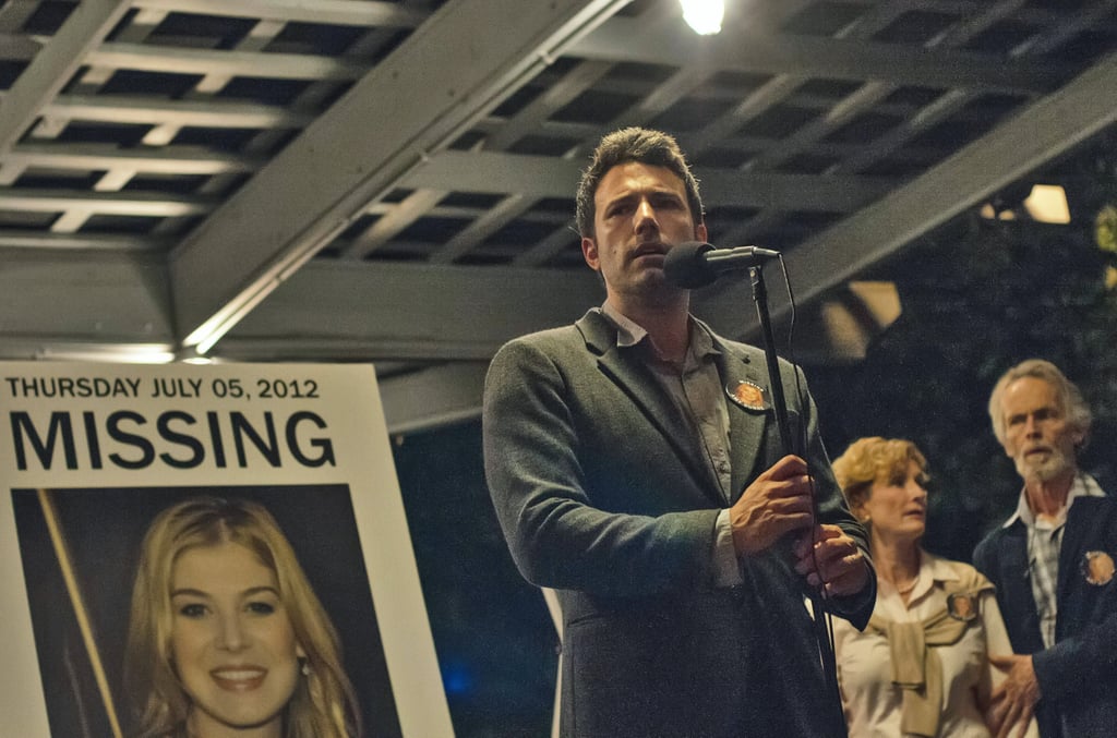 Nick looks concerned while speaking . . . But is it concern for him or for Amy (Rosamund Pike)?