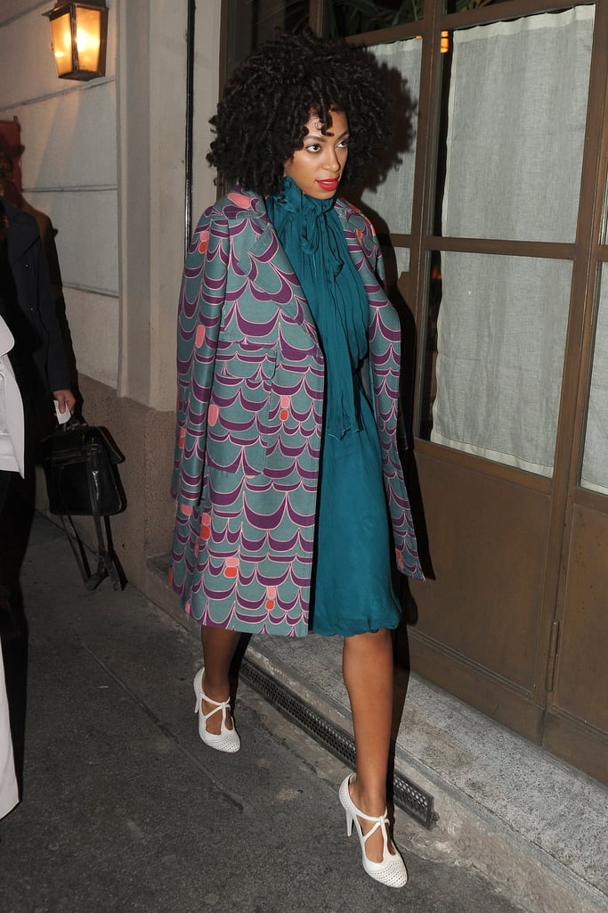 During Milan Fashion Week Fall 2012, Solange Knowles topped her teal neck-tie dress with a purple printed coat and white-hot t-strap perforated pumps.