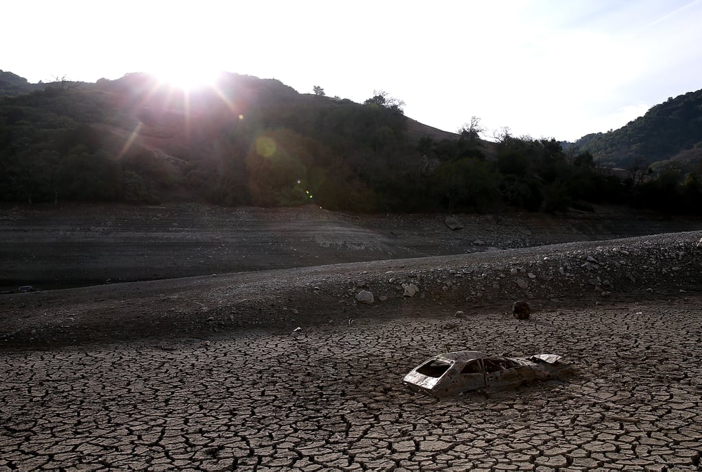 A car sits in the dried earth at the Almaden Reservoir.