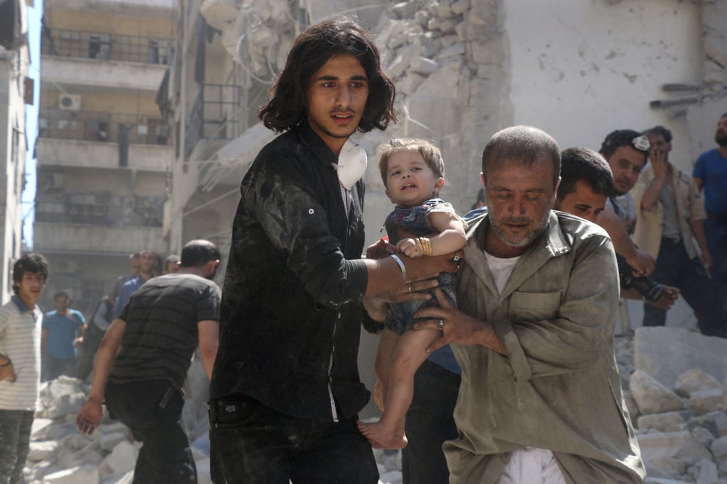 Volunteers rescue a child after an airstrike in a rebel-held neighborhood of Aleppo.