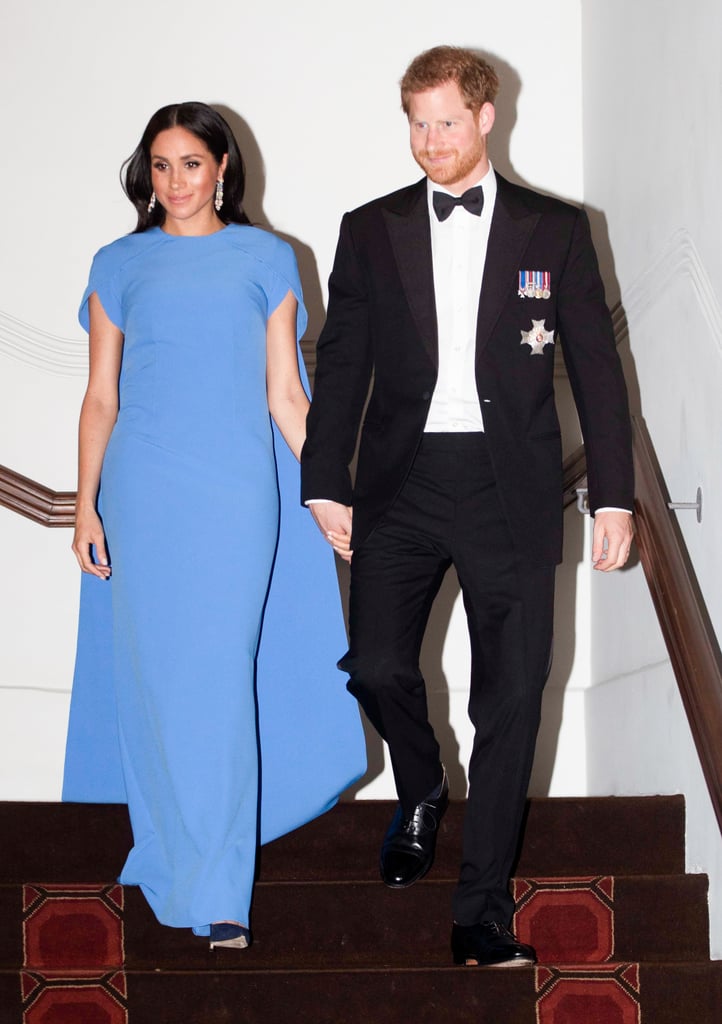 Meghan's "borrowed" chandelier earrings turned up the glamour when teamed with this Safiyaa cape gown at a state dinner in Fiji.