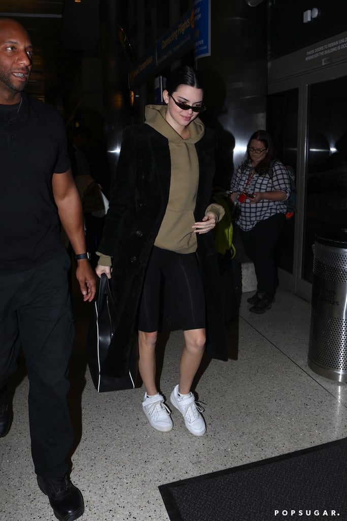 For a trip to LAX, Kendall styled a textured Balenciaga coat over an olive hoodie. She kept comfortable in Naked Wardrobe cropped leggings and slipped into her go-to Adidas Forum low-tops.