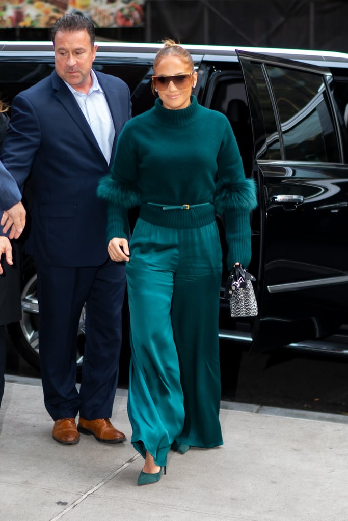 Jennifer Lopez is gorgeous in pink . . . and gold . . . and green. OK, any color, really, but especially green. Case in point: the Hustlers actress stepped out in NYC on Nov. 11 in a head-to-toe teal look that would put Emerald City residents to shame. Her cashmere turtleneck sweater with feathered sleeves and satin track pants were part of Sally LaPointe's Resort 2020 collection, and no surprise, she nailed the monochromatic ensemble.
Jennifer must be used to turning heads with her outfits by now, and I'd venture a guess that shades of green hold a special place in her heart. After all, her iconic Versace gown was green, and she's paid tribute to that particular look a few times over the past year. This time around, she kept the color more casual in an outfit that I would totally wear to my next holiday party. Thanks for the cozy inspo, J Lo! Ahead, see more photos of her getup from all angles.