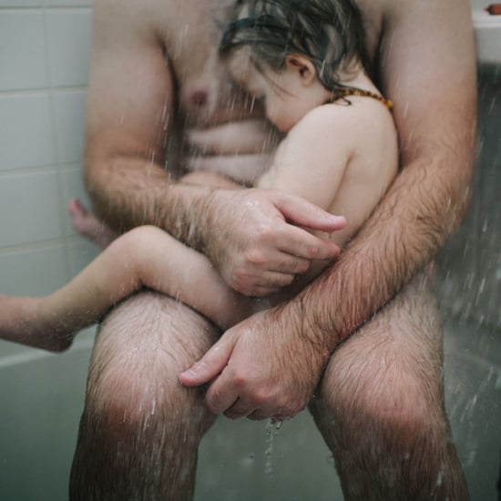 Photo of Father Holding Sick Son in the Shower