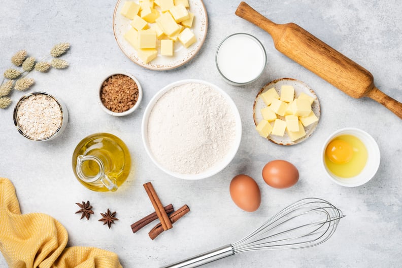 Baking ingredients on white concrete background. Flat lay composition of ingredients for making a cake, pastry or cookies