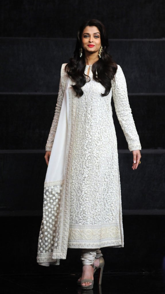 Wearing a white lace Indian outfit with ankle-strap heels.