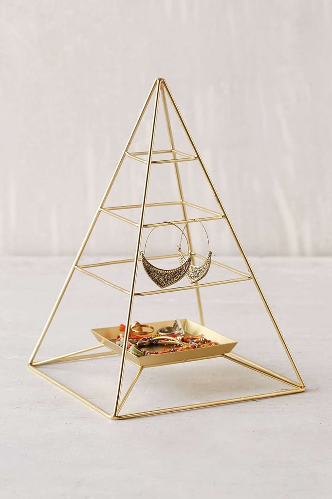 Forget jewelry trees, this sleek pyramid jewelry stand ($29) doubles as decor. 
— AE
