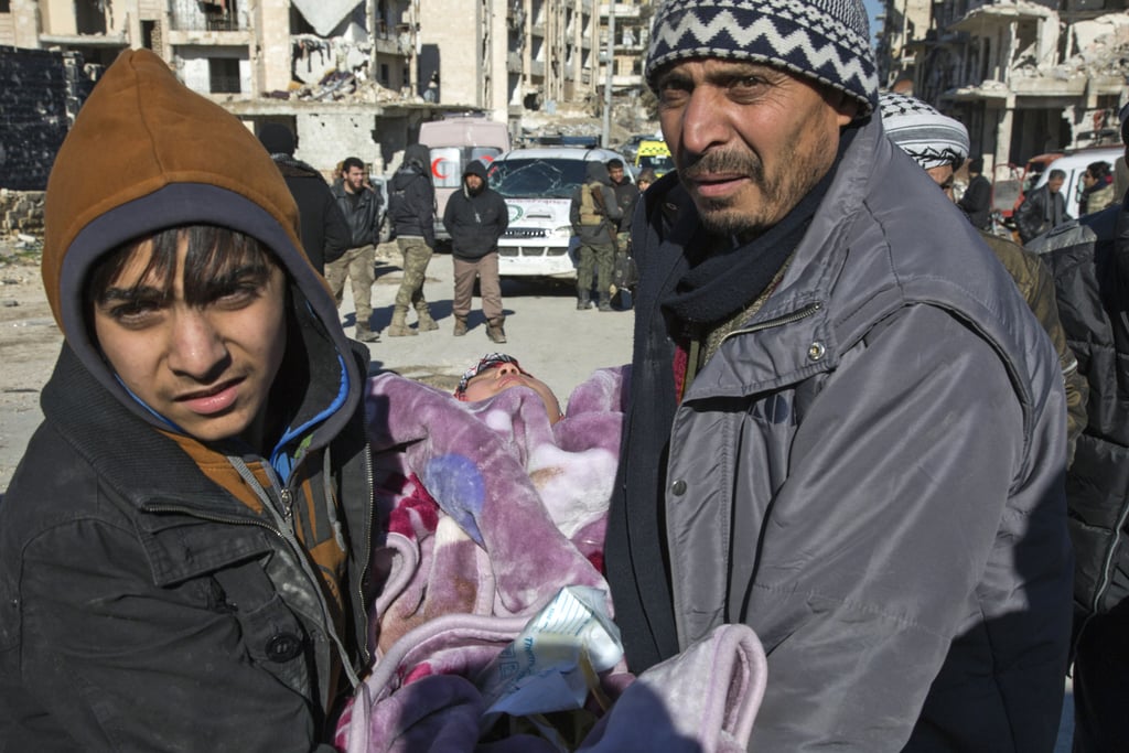 A Syrian child is carried during an evacuation of rebels and their families on Dec. 15.