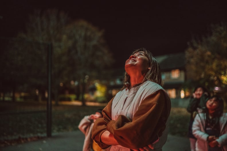 Young Woman Outside Looking Up at Sky