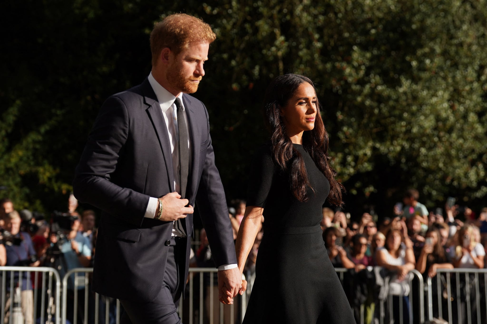 Britain's Prince Harry, Duke of Sussex (L) and Meghan, Duchess of Sussex (R) arrive to look at floral tributes on the Long walk at Windsor Castle on September 10, 2022, two days after the death of Britain's Queen Elizabeth II at the age of 96. - King Charles III pledged to follow his mother's example of 