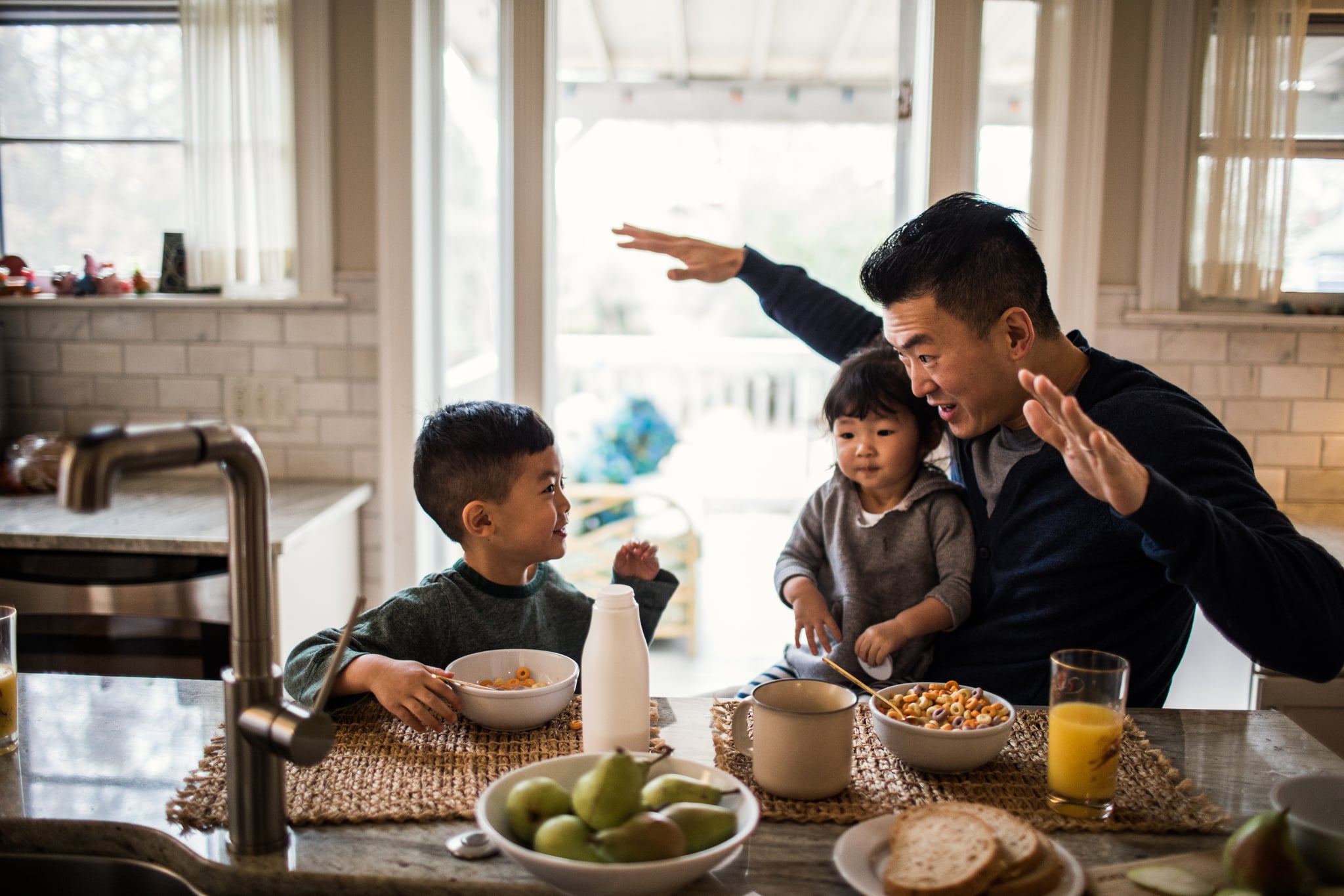 Father and children having breakfast in kitchen