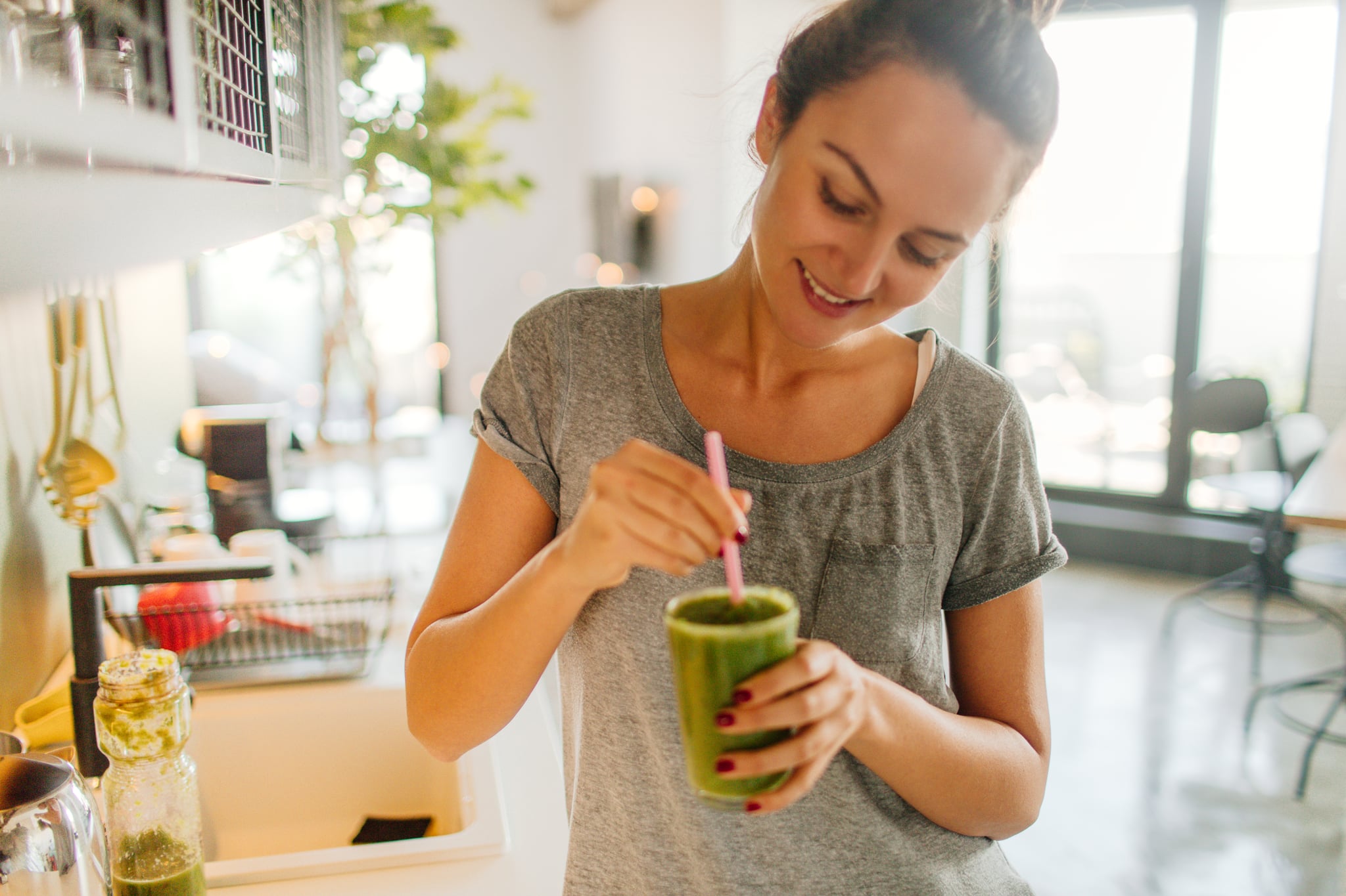 Photo of a young smiling woman having healthy breakfast in the morning