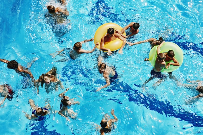 Group of kids playing together in outdoor pool overhead view