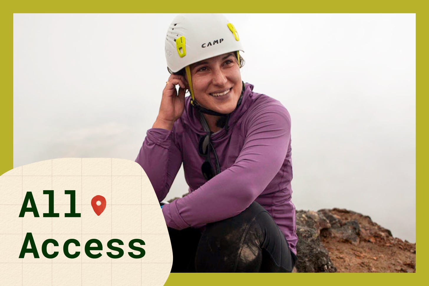 Paralympian Lacey J Henderson, a fair-skinned woman, poses on a mountain wearing a purple long-sleeve shirt, black pants, and white helmet while smiling.