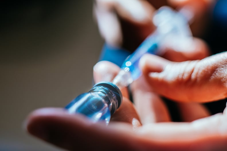 Woman preparing an injection at home, close-up.