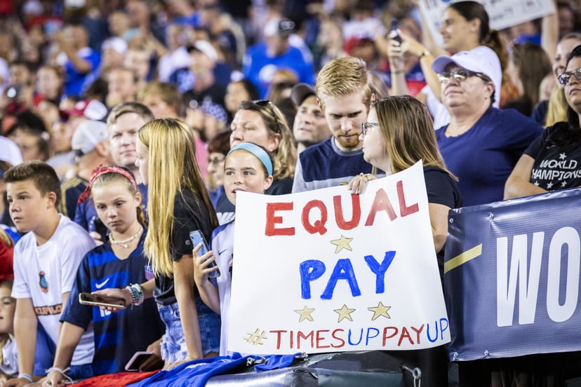 USWNT fan holds up a sign for equal pay