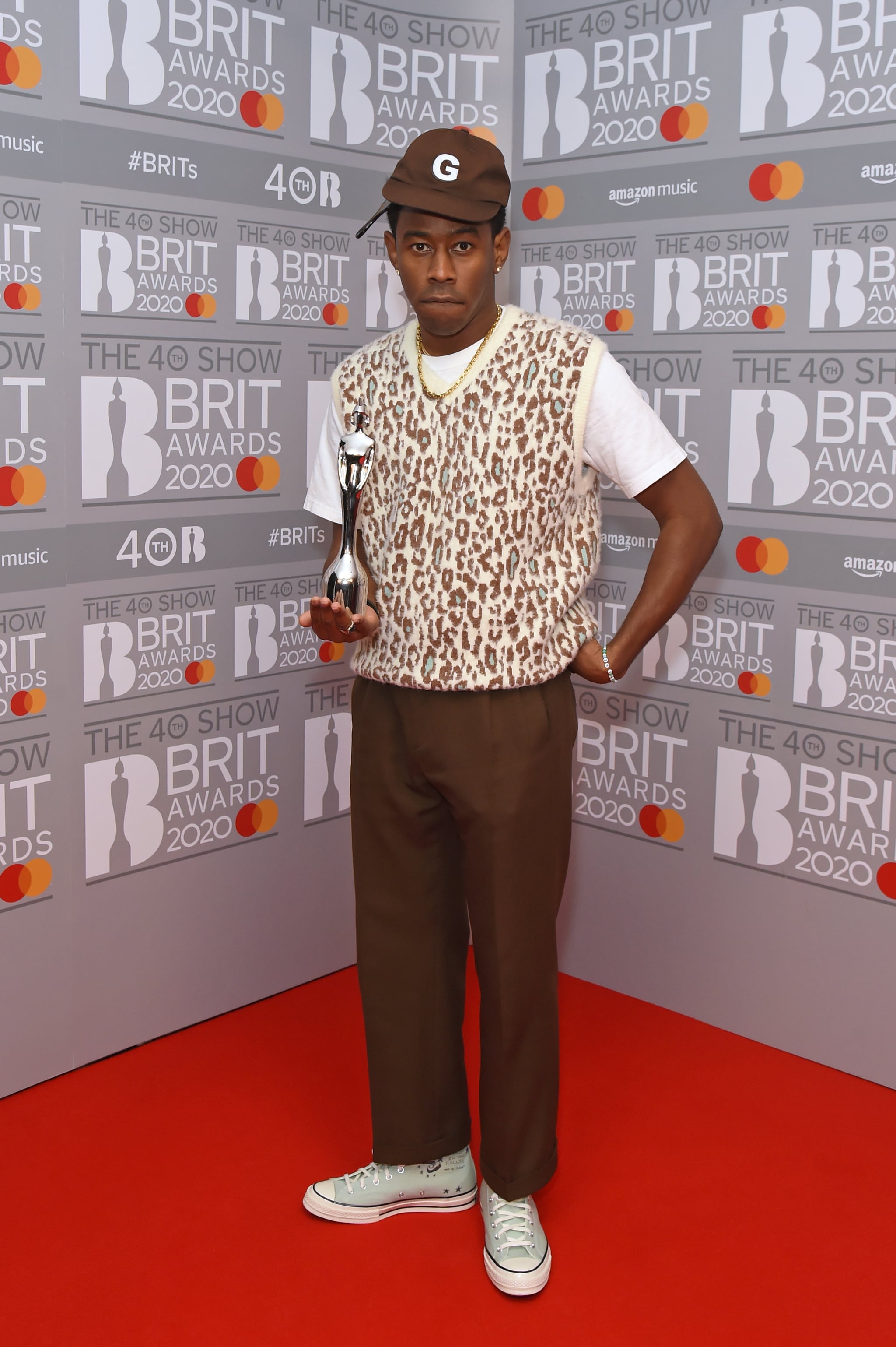 Tyler, the Creator looks relaxed in beige sweater vest and slacks