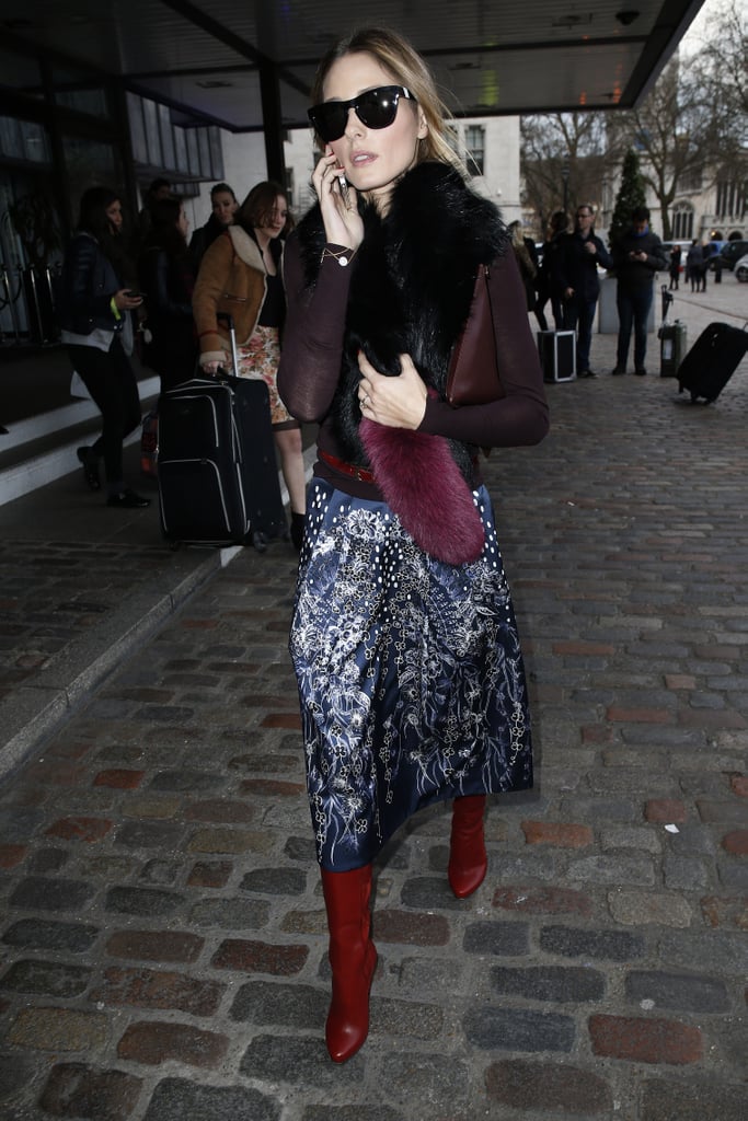 Olivia looked glamorous in a fuzzy scarf and high boots while visiting London.