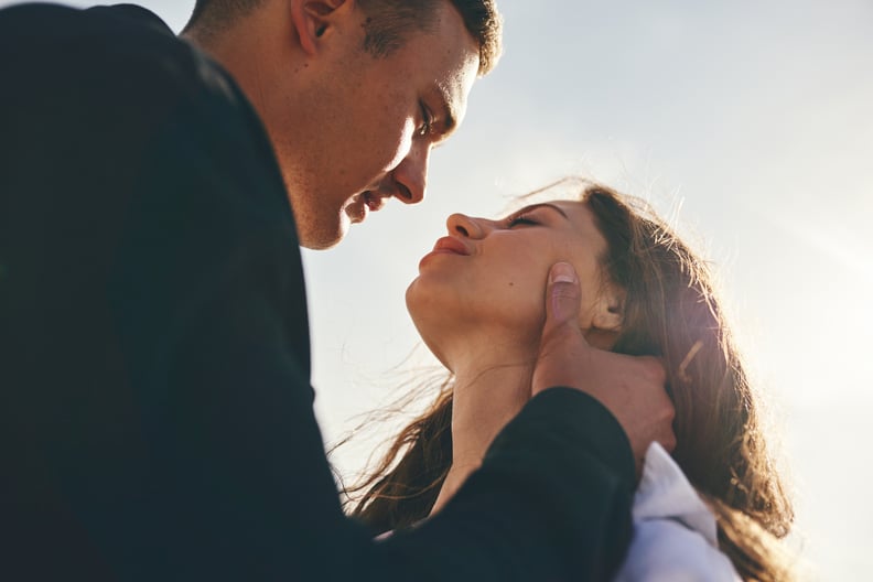 A Couple Stands Close Together and Looks Into Each Other's Eyes