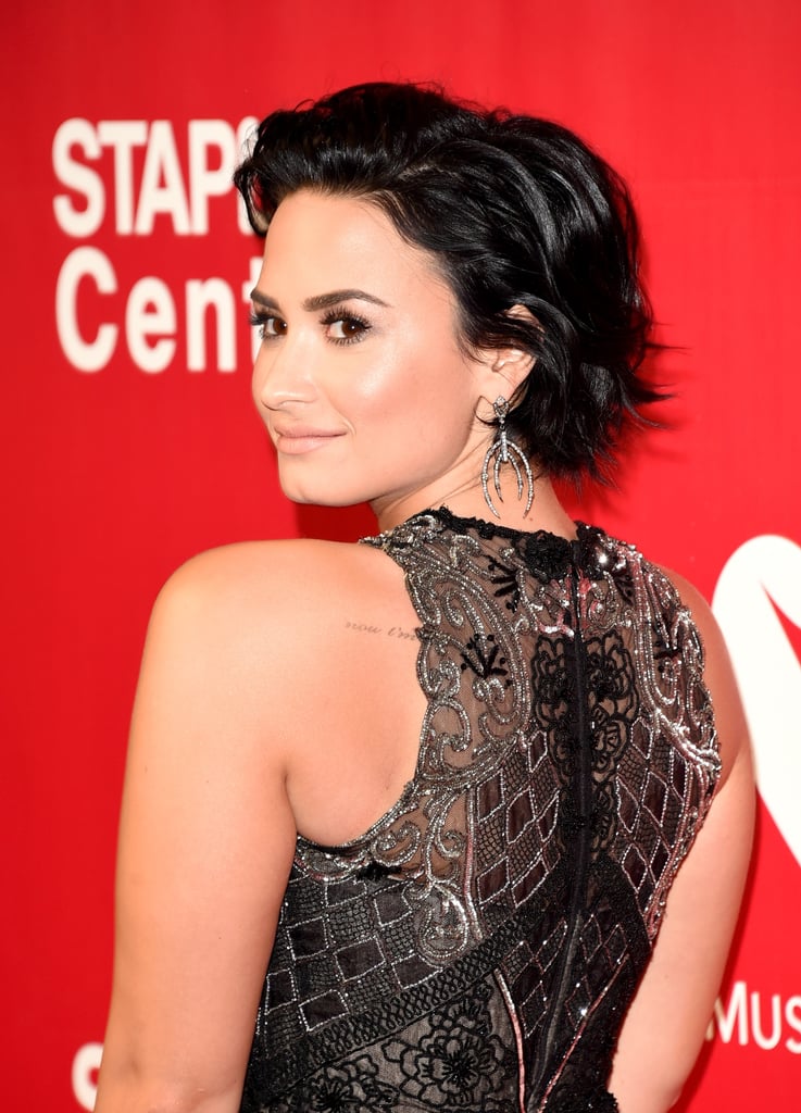 Her slicked-back hair and soft makeup let the details of her dress take the spotlight.