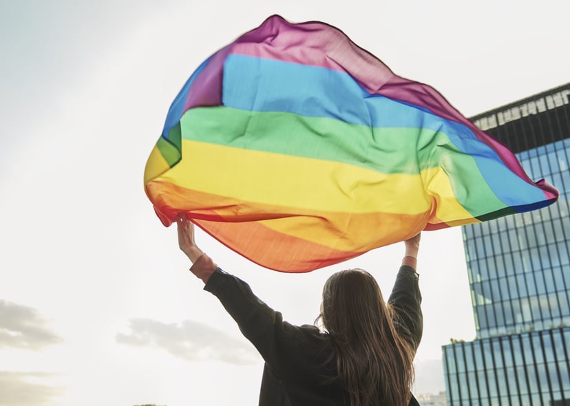 Rear view of young woman with rainbow flag