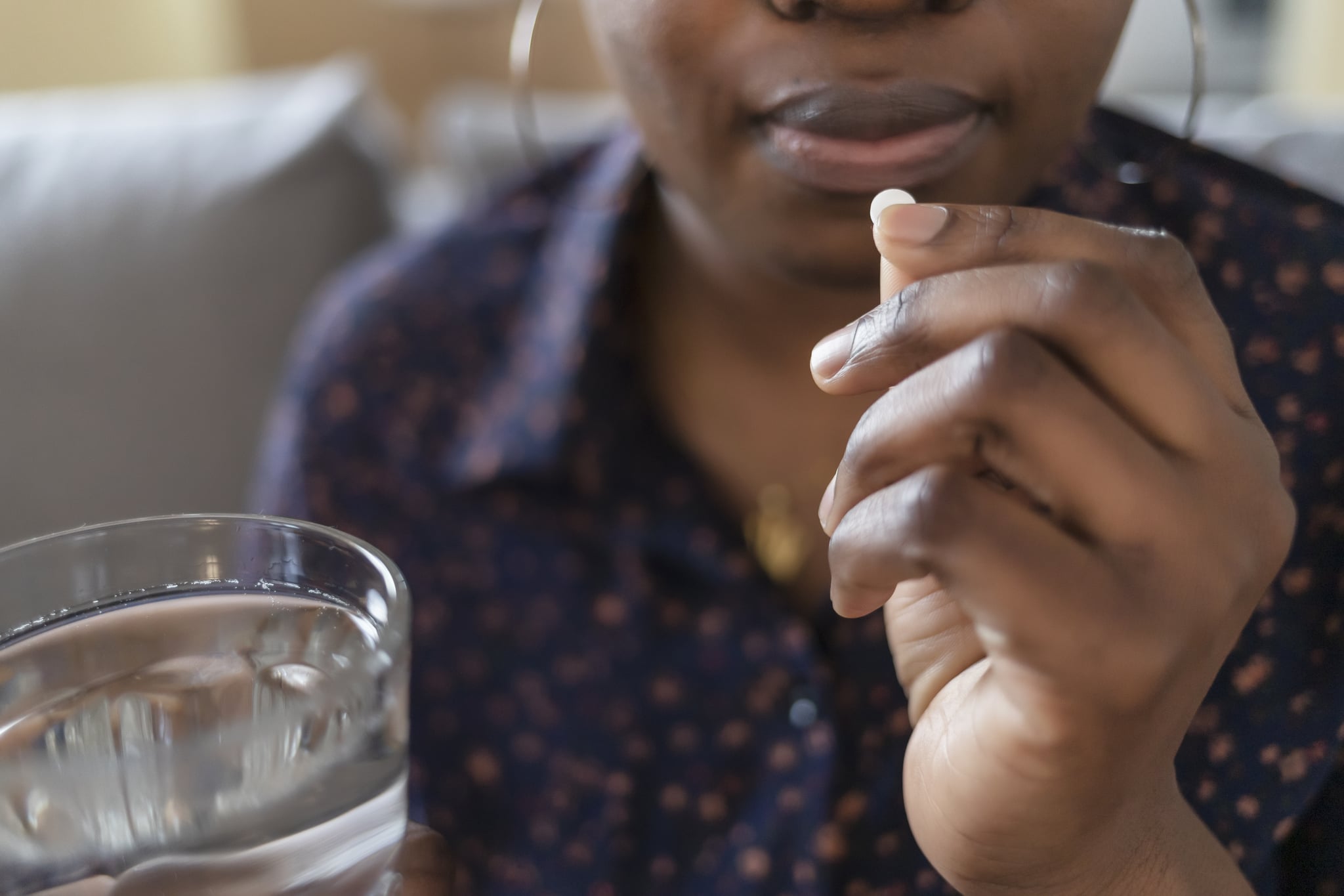 Young African-American women taking pills, supplements or antibiotics, women preparing to take the concepts of emergency medicine, chronic illness, health care and treatment.close up