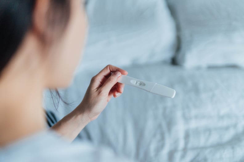 Close up shot of a young woman holding home pregnancy test. The longest wait ever. Life changing moment. Am I ready to be pregnant?
